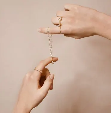Hand holding a delicate Fine Taraa necklace
